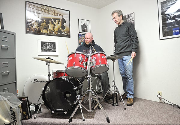 Bill Apold watches Rob Osmonson, left, during his lesson Tuesday morning at Apold Music. Eric Johnson/photodesk@austindailyherald.com