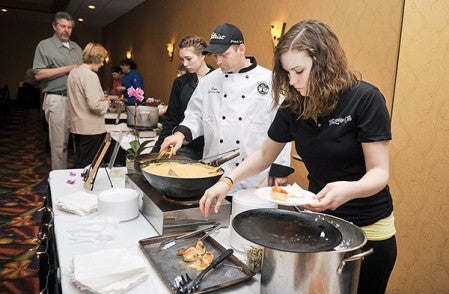 Caitlin Jacobson dishes from The Bridge Club in Grand Meadow, dishes up Thai curry scallops over Jasmin Rice during the Taste of Mower County Saturday night at the Holiday Inn and Convention Center. The Taste of Mower County is a fund-raiser for The Arc of Mower County.