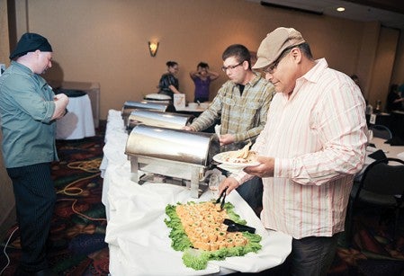 Ross Trotterchaude of Grand Meadow dishes foor from the table of the Holiday Inn's Brad George Saturday night during the Taste of Mower County, a fund-raiser for the The Arc of Mower County, held at the Holiday Inn and Convention Center.
