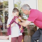 Cooper Guttormson, a Southgate third-grader, gets an autograph from Gopher Mens Hockey coach Don Lucia Monday in Austin.