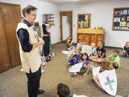 Pastor Tomas Ogilvie talks to kids about the Bible during St. John's Lutheran Church's vacation Bible School Thursday morning in the church.