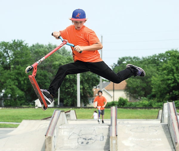 Collin Wilson catches big air coming off a ramp during the scooter competition of a fundraiser for new equipment at the Austin skate park Friday afternoon. Eric Johnson/photodesk@austindailyherald.com