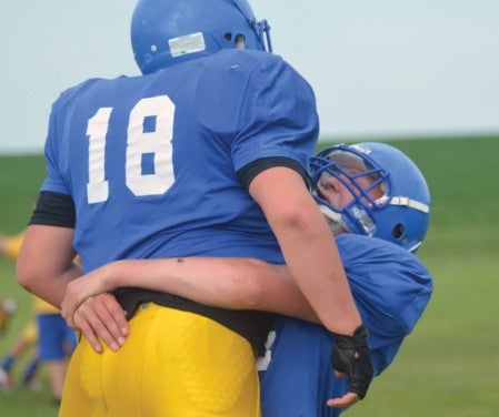 Hayfield's Dyland Arndt lifts teammate Sam Olive during a tackling drill in practice in Hayfield Thursday. -- Rocky Hulne/sports@austindailyherald.com