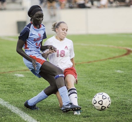 Ausitn's Sela Fadness moves the ball away from Albert Lea's Becca Dup during the first half Thursday night at Art Hass Stadium. Eric Johnson/photodesk@austindailyherald.com