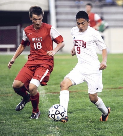 Austin's Franco Ortiz is challenged by Mankato West's Dillon Lambert as he moves the ball forward during the first half Tuesday night at Art Hass Stadium. Eric Johnson/photodesk@austindailyherald.com