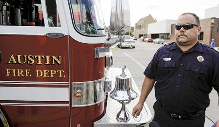 Austin firefighter Jim Halsey rings the bell in memory of firefighters who died in the 9/11 attacks during a Patriot Day observance Wednesday night at the Veteran's Memorial. Eric Johnson/photodesk@austindailyherald.com