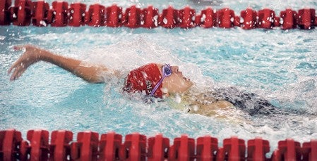 Austin's Emma Kleis kicks off the 200 medley relay with the backstroke during the Packers' dual Thursday night against Rochester Century. Eric Johnson/photodesk@austindailyherald.com