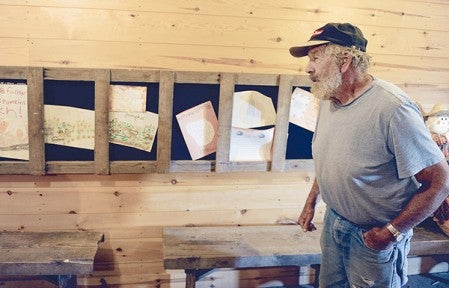 Children have always been happy to visit Farmer John's Pumpkin Patch. Here he stands next letters and pictures Farmer John and his wife Jan have received over the years. Eric Johnson/photodesk@austindailyherald.com