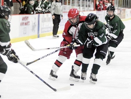 Austin's Myia Hoium battles with Faribault's Alex Ferris for the puck during the first period Thrusday night at Riverside Arena. Eric Johnson/photodesk@austindailyherald.com