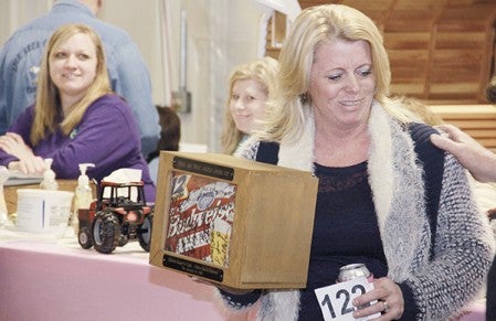 Martha Vrieze bought Sharon Kaput’s 12-pack of beer for $750 during the Lyle Area Cancer Auction last year in the Lyle maintenance building. It was the 15th year the 12-pack had been auctioned off and the third time Vrieze purchased it. Herald file photo