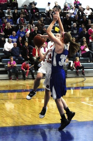 Austin's Merideth Fritz attempts a lay-up over Owatonna's Katlin Ptacek during the Packers' 64-35 loss on Friday at Owatonna High School. -- Kaleb Roedel/Owatonna People's Press