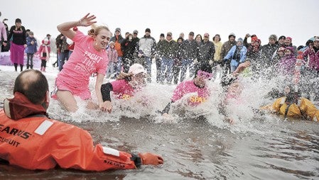 A group of four hit the chilly waters of East Side Lake last year’s Polar Plunge for Pink. The event returns at 3 p.m. on East Side Lake on Feb. 15. Herald file photos