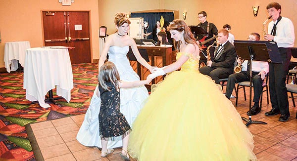 Cinderella and Belle dance with a little girl at the Black and White Ball Friday inside the Holiday Inn. The ball raised about $10,000 this year thus far, according to Dagna Simmons, captain for Team IBI Data. Last year, the ball raised about $12,000. Simmons said more than 200 people attended the ball Friday. Trey Mewes/trey.mewes@austindailyherald.com