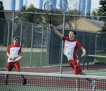 Austn's Ethan Anderson reaches for a smash during the No. 2 doubles match against Faribault Tuesday afternoon at Paulson Courts. Eric Johnson/photodesk@austindailyherald.com