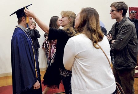 Kris Steiner straighens the tassles of her son Matthew Steiner of Brownsdale before Riverland Community College commencement exercises Friday night at Austin High School. Eric Johnson/photodesk@austindailyherald.com