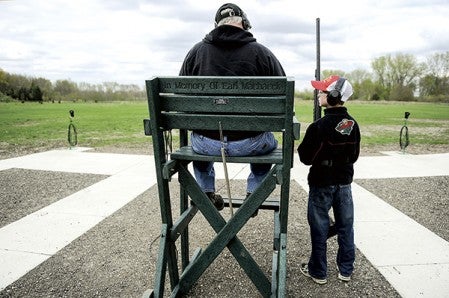 William Grunewald waits to see his score as Bill Adams tallies during a competition shoot at the Cedar Valley Conservation Club.  Eric Johnson/photodesk@austindailyherald.com