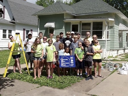 Volunteers pose for a picture in front of a house after it was finished. Photo provided.