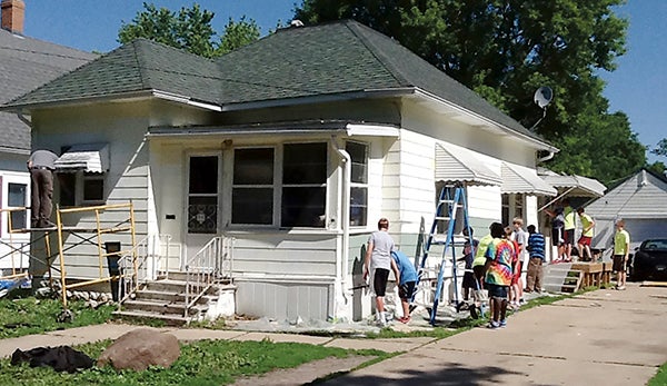 CHIP volunteers paint a project house.  Photo provided