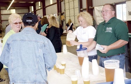 Nan Hanegraaf and John Bhend serve beer at the cookout.