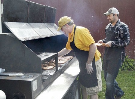 Mark Kanne (Left), kitchen manager of Hy-Vee, and Brian Neuvirth from Mower County Pork Producers cook Windsor pork chops at the start of the Chamber of Commerce Ag Appreciation Cookout on Tuesday.   “Our grill couldn’t keep up because the crowd kept growing and growing, so we had to get a bigger grill,” Neuvirth said.