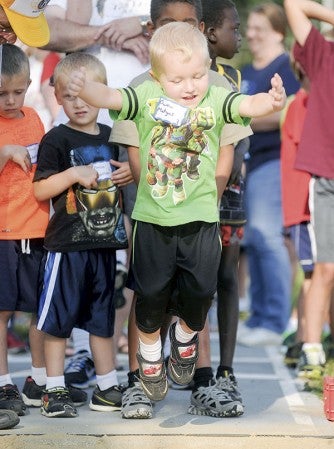 Three-year-old Owen Matyas takes a jump during the standing long jump at Gene Roden Memorial Track Meet Thursday night at Larry Gilbertson Track and Field. 