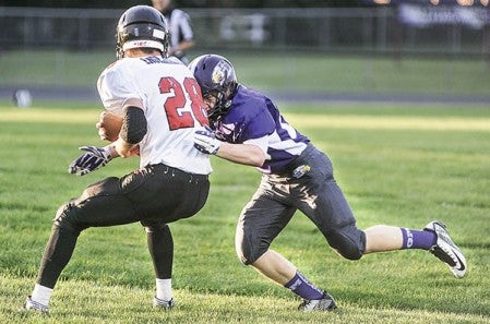 Grand Meadow's Christopher Bain puts a hit on Spring Grove's Josh Graves in the first quarter Friday night in Grand Meadow. Eric Johnson/photodesk@austindailyherald.com