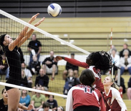 Austin's Awenia Nywesh spikes against Winona Thursday night in game one in Packer Gym. Eric Johnson/photodesk@austindailyherald.com