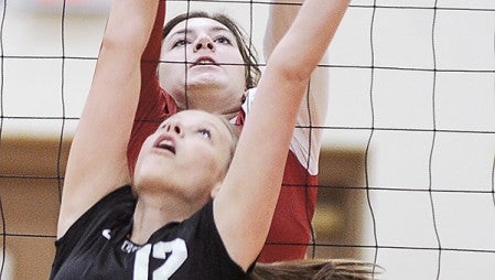 Austin's Alex Hansen puts up a block in front of Winona's Maria Appicelli during game one Thursday night in Packer Gym. Eric Johnson/photodesk@austindailyherald.com