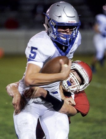 Austin's Seth Clasen wraps up Owatonna's Alex Emanuelson during the third quarter Friday night at Art Hass Stadium. Eric Johnson/photodesk@austindailyherald.com