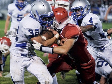 Austin's Zach Coffey, right, hits Owatonna's Julius Franklin (32) during the  second quarter Friday night at Art Hass Stadium. Eric Johnson/photodesk@austindailyherald.com