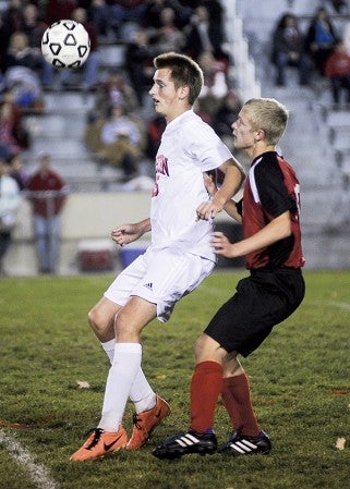 Austin's Noah Brehmer holds off Cannon Falls' Michael Monson during the first half of their playoff game Tuesday night at Art Hass Stadium. Eric Johnson/photodesk@austindailyherald.com.