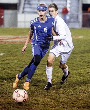 Austin's Alex Evenson challenges Kasson-Mantorville's Andy Plein during the first half of their playoff game Saturday at Art Hass Stadium. Eric Johnson/photodesk@austindailyherald.com