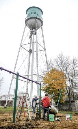 Volunteers set posts for a swing set in the Brownsdale Park Friday. Photos by Eric Johnson/photodesk@austindailyherald.com