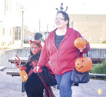 Emily Ellingson; 7; walks with her grandmother; Annie Tapp. Ellingson won second place in a costume contest for her devilish dress-up. 