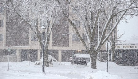 Heavy snow from last February's storm falls as a loader removes snow from the drive of Twin Towers Thursday afternoon. Herald file photo