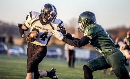 Blooming Prairie's Cole Byers-Sunde runs runs past Rushford-Peterson's Noah Carlson for a score in the first quarter of the Section 1A championship Saturday night in Rochester. Eric Johnson/photodesk@austindailyherald.com