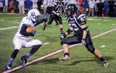 Blooming Prairie's Scott Romeo steps up to contain Minneapolis North's Keyon Thomas during the second quarter Friday night in the quarterfinals of the Class A Minnesota State Football Tournament in Richfield. Eric Johnson/photodesk@austindailyherald.com