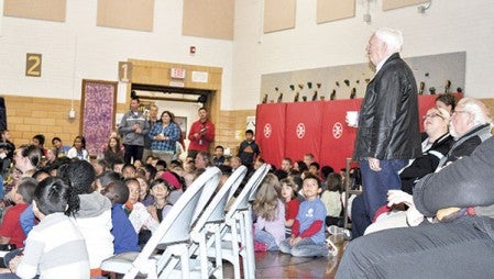 A veteran stands to be recognized Tuesday morning during an assembly in the Sumner Elementary School gym.