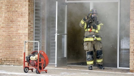 An Austin firefighter signals for a pike as firefighters worked Wednesday morning to knock down a dryer fire at the Maytag Coin Laundry. Eric Johnson/photodesk@austindailyherald.com