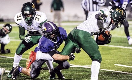 Grand Meadow's Jordan Miland gets hands on Kittson County Central's Carson Thorsteinson during the third quarter in the Minnesota State Nine Man semifinals Friday night in St. Cloud. Eric Johnson/photodesk@austindailyherald.com