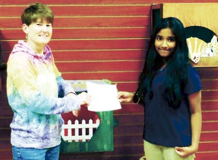 Mower County Kelly Rush, right, receives a check for $491.44 from Shenali DeSilva, a 12 year old Pacelli Catholic Schools student. Shenali spearheaded a four-week fundraiser for the Mower County Humane Society at Pacelli that resulted in the donation to shelter.      Photo provided         