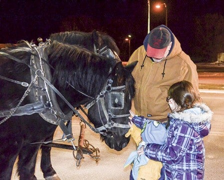 Nathan Rembao, 3, and his sister Rachel Rembao, pet the horses giving sleigh rides at the Walmart parking lot. The horses were owned by Don Konken, who has done the sleigh rides for about 20 years.