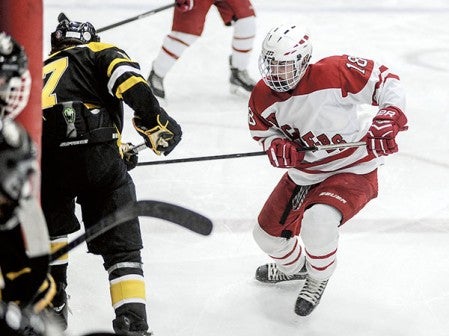 Austin's Trevor Stevens, right, challenges Mankato East's Hunter Johnson against the boards in the third period Tuesday night at Riverside Arena. Eric Johnson/photodesk@austindailyherald.com