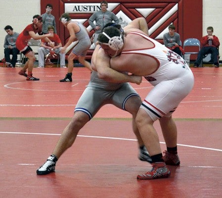 Austin's Eli Kaercher grapples with a heavyweight wrestler from Owatonna in Packer Gym Tuesday. -- Rocky Hulne/sports@austindailyherald.com