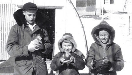 Ted (left) Dan and John hold Ted’s homing pigeons. Photo provided