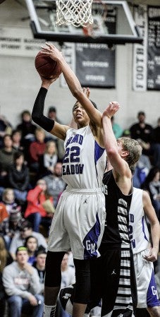 Grand Meadow's Terrell Rieken goes up for two in the first half in front of Blooming Prairie's John Rumpza Friday night in Blooming Prairie. Eric Johnson/photodesk@austindailyherald.com