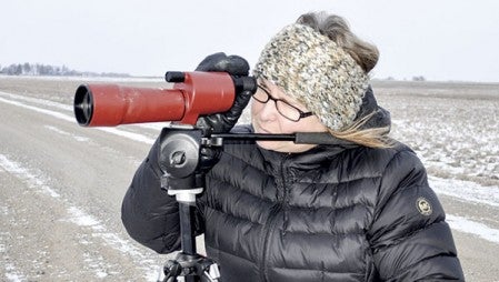 Merlene Stiles, president of the Audubon Club, looks through a spotting scope Monday afternoon to look for a snowy owl. 