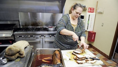 Chef Amy Riley cuts up tamarind glazed pork loins prior to tasting.