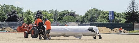 Another roll of artifical turf is rolled out as crews worked Friday installing the surface on Art Hass Stadium. Eric Johnson/photodesk@austindailyherald.com