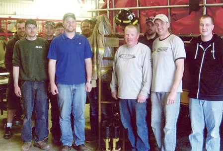 The Lyle Volunteer Fire Department stands next to the memorial ladder given by Worlein Funeral Home.  Photo provided